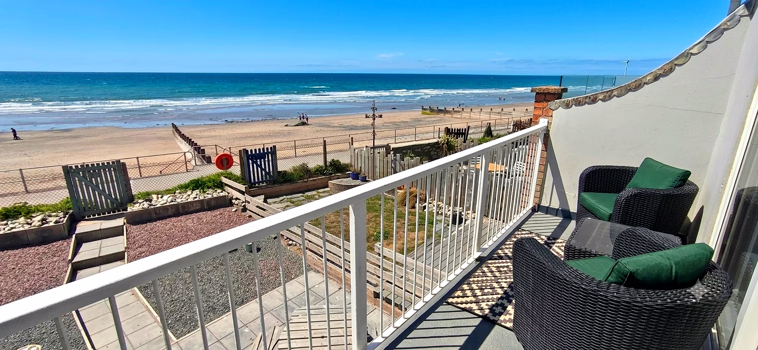 Venedotia first-floor balcony with rattan seating overlooking Tywyn beach and Cardigan Bay